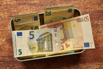 banconote in euro in una latta di cioccolato