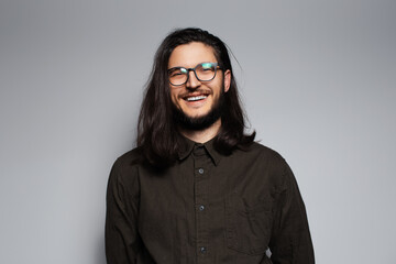 Obraz premium Portrait of young smiling attractive man with long hair and glasses.