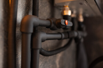 Close-up of black connected polypropylene pipes and tap.