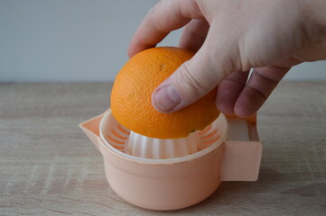 preparation of freshly squeezed orange juice on a hand strainer, 100% fruit juice for a healthy...