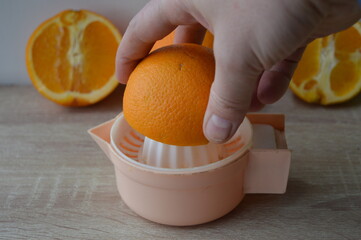 preparation of freshly squeezed orange juice on a hand strainer, 100% fruit juice for a healthy...