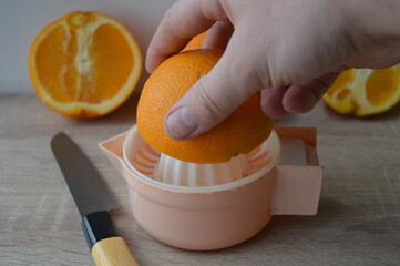 preparation of freshly squeezed orange juice on a hand strainer, 100% fruit juice for a healthy...