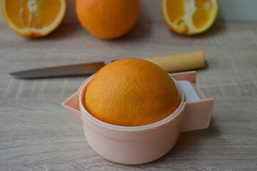 preparation of freshly squeezed orange juice on a hand strainer, 100% fruit juice for a healthy...
