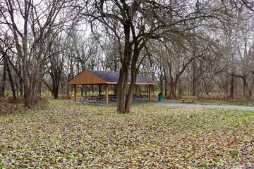 The wood picnic shelter in the park on a autumn day.