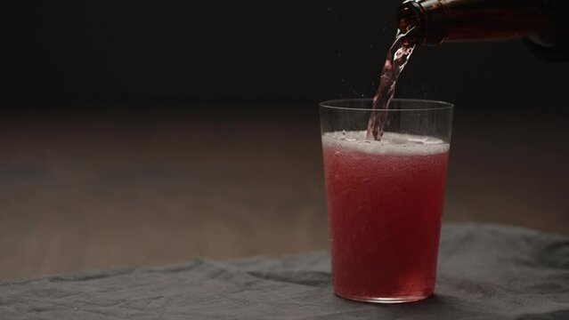 Slow motion pour berry drink into tumbler glass with copy space