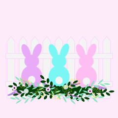 Easter bunnies in flowers near the fence