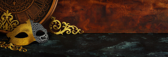 Photo of black with gold elegant Venetian mask over grunge background