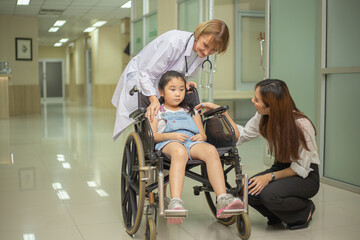Fototapeta na wymiar A doctor is pushing a young patient down the hospital corridor with her mother.