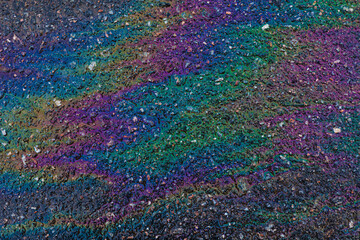 Fototapeta premium Bright, vivid and colorful backgrond or backdrop of oil, gas or petrol rainbow spots on asphalt or bitumen surface