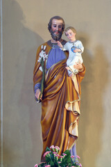 Fototapeta premium Saint Joseph holding baby Jesus statue in the parish church of Saint Nicholas in Jastrebarsko, Croatia