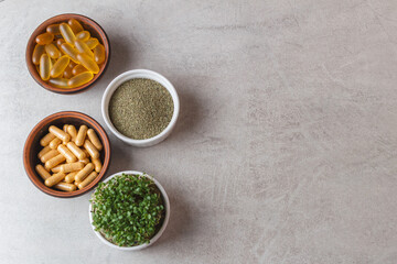 Microgreens, herbal powder and pills on a gray background. copy space