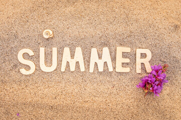 the inscription summer is laid out on the sand with wooden letters