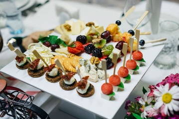 Appetizers on plates. Catering service. Wedding welcome food..Canapes (shrimp, mozzarella, sun-dried tomatoes). Welcome buffet at the event.