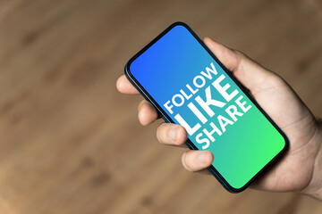 Follow Like Share - hand holding a phone