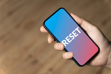 Reset - hand holding a phone