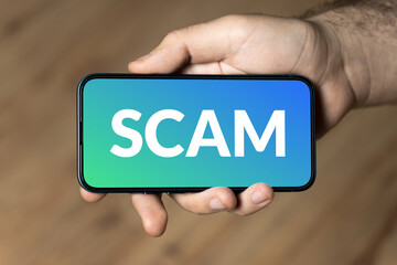 Scam - hand holding a phone