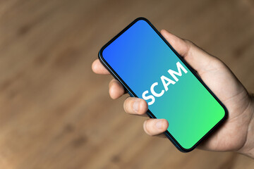 Scam - hand holding a phone