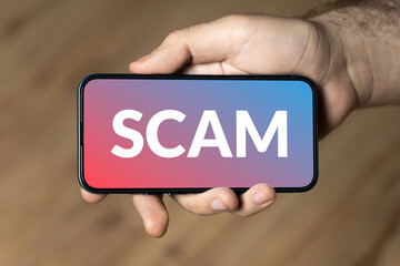 Scam - hand holding a phone