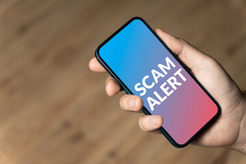Scam alert - hand holding a phone