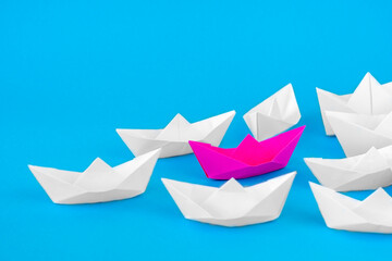  pink paper ship leading among white. Paper Boats.