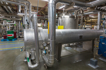 Process heat exchanger at the insulation in process area of pipeline flowing stainless chemical in a factory at control room