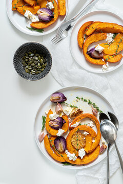 Roasted pumpkin,onion, garlic , thyme, rosemary and pampkin seeds on white background. Rustic food photography.  Close-up. Top view.