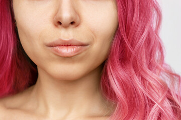 Close-up of the wavy deep pink hair of a young woman isolated on a white background. Result of...