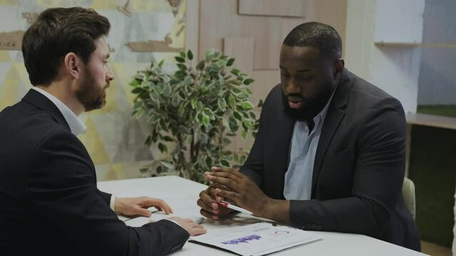Sales representative and analytic tries to convince his customer with details and charts.