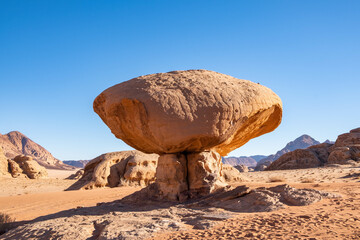Scenic View Caravan of Camels Resting in the Shade of Mushroom Shaped Rock in Wadi Rum Desert, Jordan