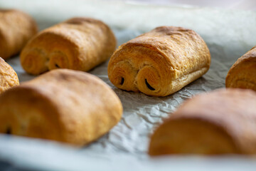 Close up freshly baked chocolate croissants on tray. Traditional french pastry.