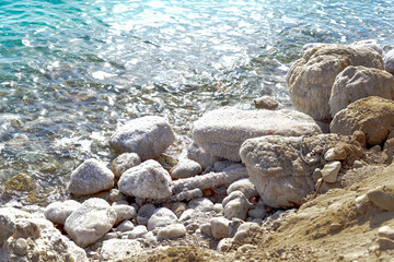 Obraz premium Close up of salt background. Natural salt. Dead Sea salt mineral natural formations. Salt crystals from Dead sea. View of Dead Sea coastline. Texture of Dead sea. Salty seashore rocks