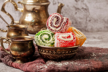 Traditional Turkish delight with Turkish tea on gray background. Ramadan Kareem celebration concept. Fragrant Turkish tea and Turkish sweets in national dishes.