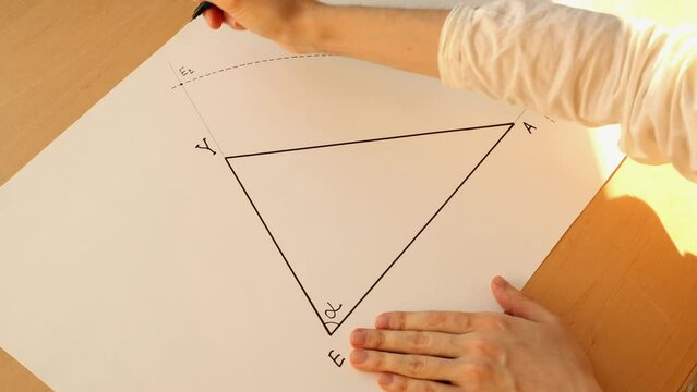 Young mathematician hands marks crossing point "E2" for constructing angle bisector. Date of shooting day 25 January 2022 year, MSK time. This video was filmed in Russia.