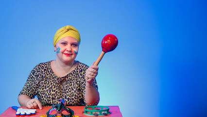 A Jewish woman in a headdress with a painted Magen David face leads the noise on Purim while...