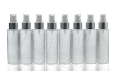 Row of transparent spray bottles with liquid isolated on a white background.