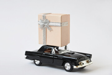 Retro black car with pink gift upside. Concept delivery gift ideas on covid 19