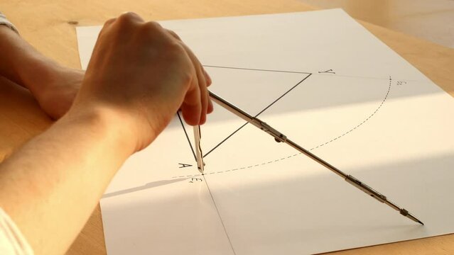 Young mathematician hands are drawing an arc of a circle for construction angle bisector. Date of shooting day 25 January 2022 year, MSK time. This video was filmed in Russia.