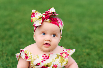 Outdoor portrait of adorable baby girl wearing colorful headband