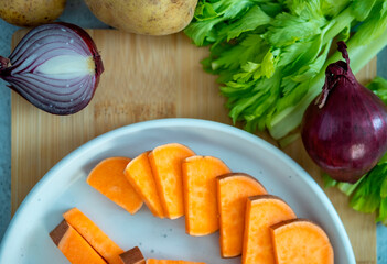 Sweet potato on a wooden board. Preparing vegetable soup