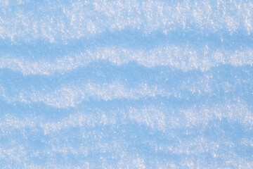 Close-up of fresh snowy land in the winter on a sunny day, viewed from above. Abstract full frame textured background. Copy space. Top view.