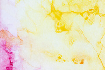 Macro close-up of yellow and pink alcohol ink layers and splashes on white, abstract background. Fluid ink, colorful full frame textured background. Vibrant color. Art for design.