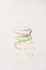 Beauty, skincare products setting. Colorful pink, green, transparent cosmetic cream smear isolated on white background