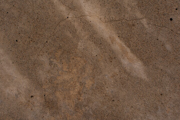 Texture of concrete with a shadows and spots. Close-up. Inclusions of sand of different colors. Old cracked surface.