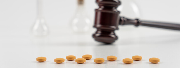 Medicine and law. Pills capsules and judge gavel isolated on white background.