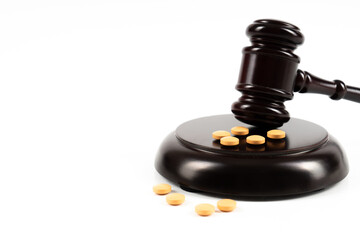 Medicine and law. Pills capsules and judge gavel isolated on white background.