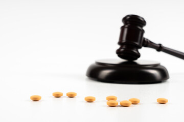 Medicine and law. Pills capsules and judge gavel isolated on white background.