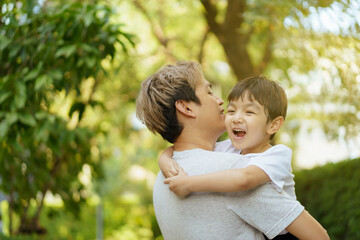 Happy Asian little boy enjoy playing and walking at the park with daddy.
