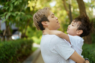 Fototapeta premium Happy Asian little boy enjoy playing and walking at the park with daddy.