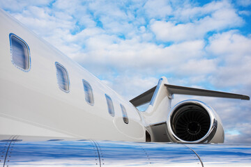 part of modern private business jet airplane with a tail and wing over sky background