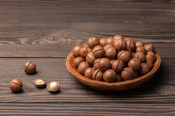 macadamia nuts in a wooden bowl on the dark table